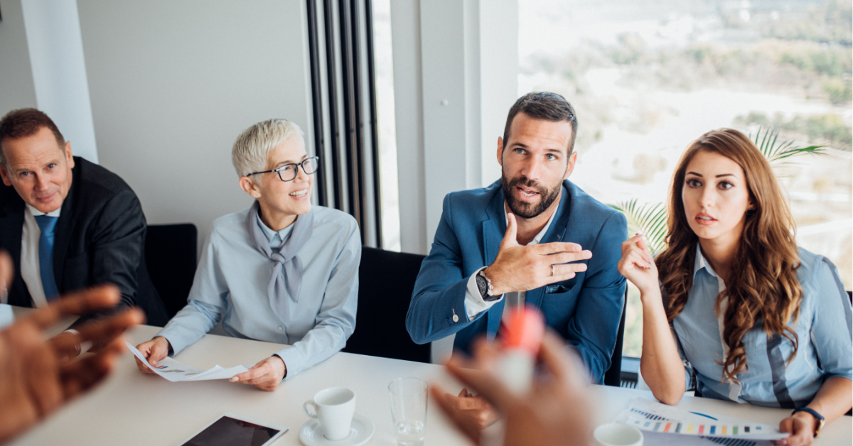 Co-workers of a variety of ages discuss business during a meeting.