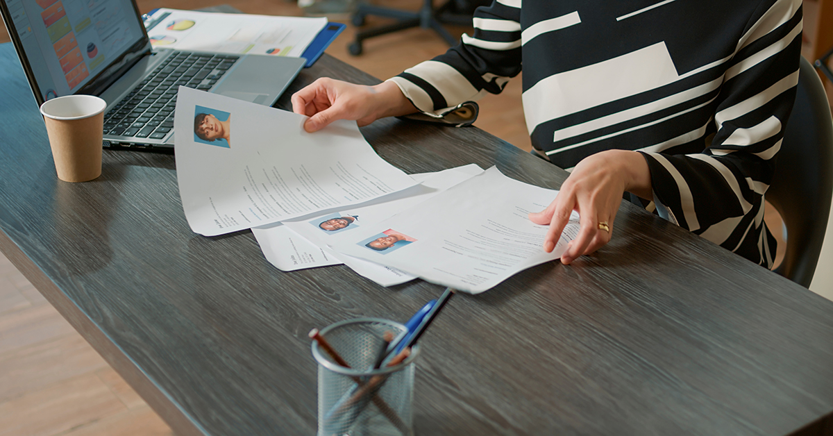 A human resources administrator reviews resumes for an open position.